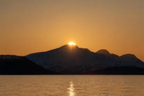 Die Mitternachtssonne über der Insel Reinøya im Ullsfjord in Norwegen