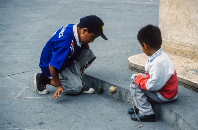 Children play with spinning tops