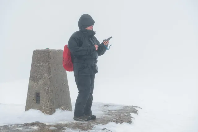 Karin am Markierungsfels der Spitze des Ben Nevis beim Geocaching.